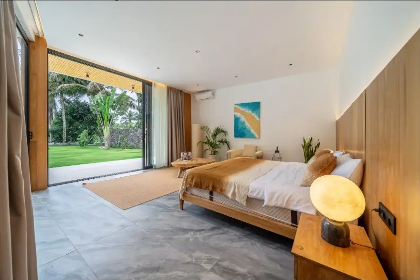 Luxury villa bedroom with garden views and natural wood furnishings